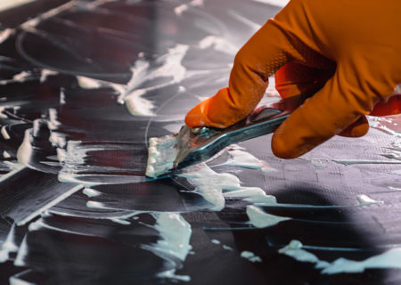 cleaning glass stovetop with metal scraper