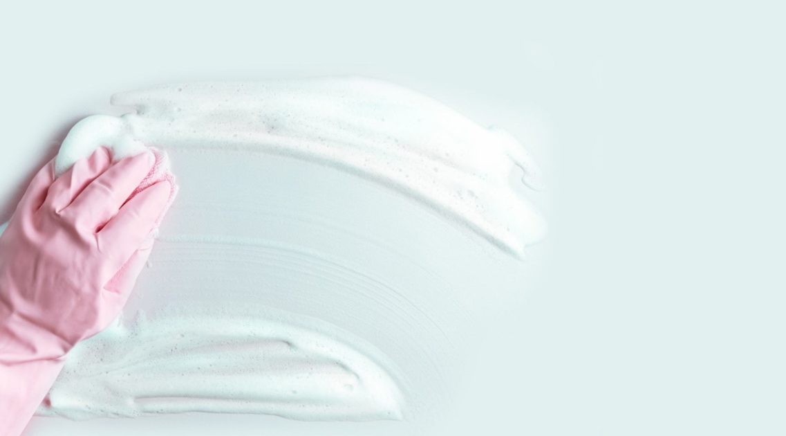 cleaners hand wiping off soap suds